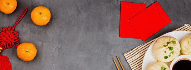 中国新年的装饰用饺子，橘子，酱油，筷子，红包在灰色的混凝土背景。2020年春节快乐图片下载