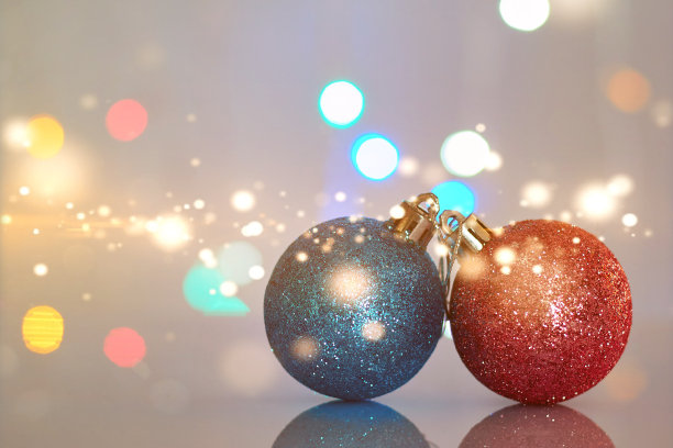 两个圣诞玩具在耀眼的背景下。照片适合设计师的明信片或海报。图片下载