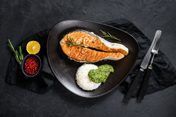 烤鲑鱼排配米饭和菠菜。健康的海鲜。黑色背景。俯视图图片下载