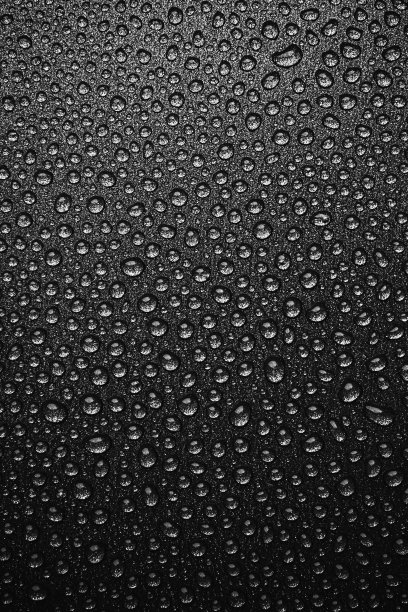 摘要背景:许多水滴在深色的表面-不粘涂层在平底锅。黑白照片图片下载