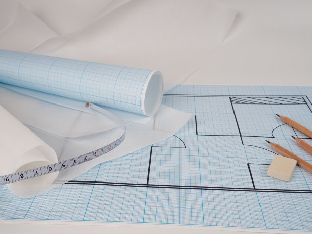 在图纸上进行规划，规划施工的过程和舒适的家，帕丘卡新公寓的新设计。绘图用的方格纸、铅笔和卷式方格纸图片下载