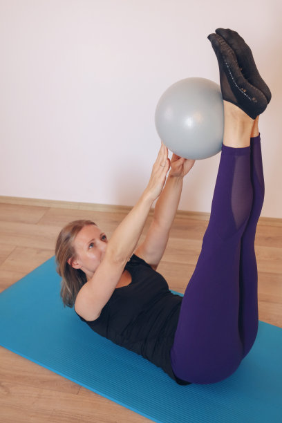 核心和腿部普拉提训练与迷你球。运动和女性气质，伸展运动。图片下载