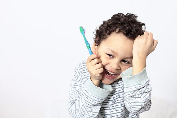 男孩用电动牙刷刷牙的照片图片下载