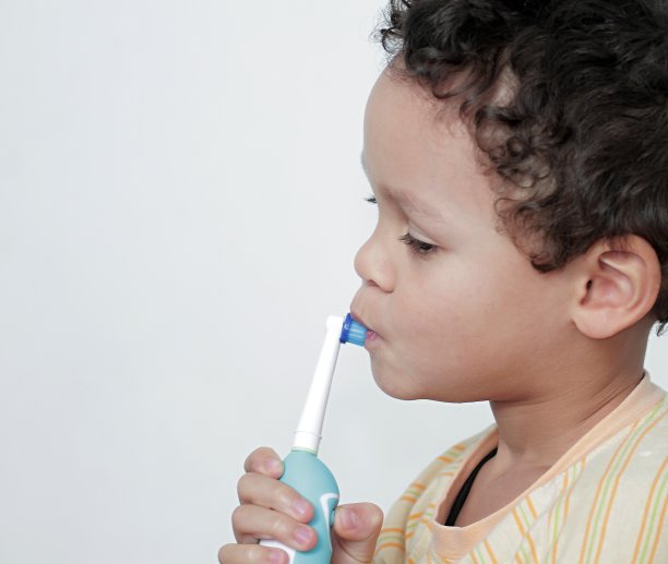 男孩用电动牙刷刷牙的照片图片下载