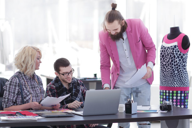 在工作室的桌子上，充满欢乐的设计师团队。带拷贝空间的照片图片下载