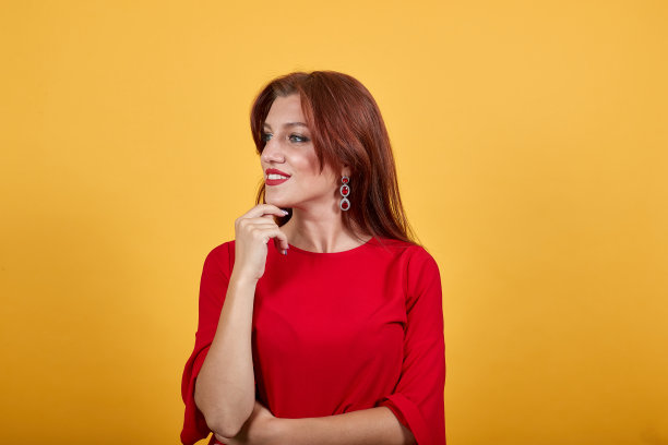 微笑的女孩拿着她的右手靠近下巴，看起来很高兴。图片下载