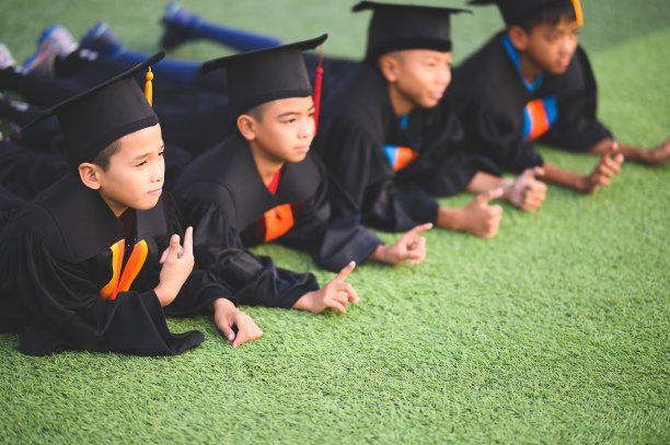 一群男孩在学校的毕业典礼上兴高采烈。图片下载