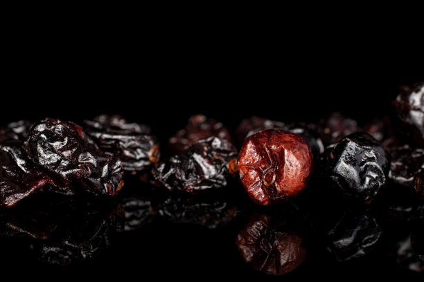 隔在黑色玻璃上的干越橘图片下载