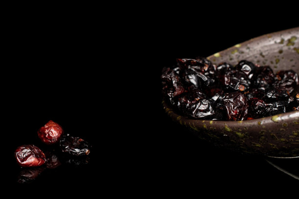 隔在黑色玻璃上的干越橘图片下载