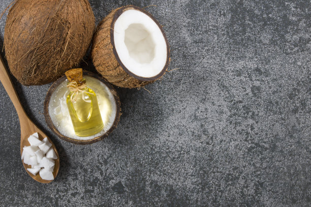 玻璃瓶椰子油与新鲜的椰子水果在乡村的背景，替代疗法医学概念，椰子nucifera图片下载