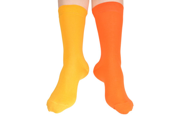 黄色和橙色的袜子上的女人脚孤立在白色的背景。图片下载