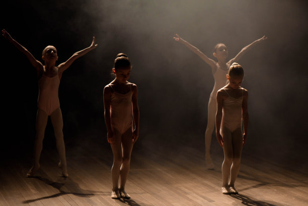 一群小型芭蕾舞者在灯光和烟雾中在舞台上排练图片下载