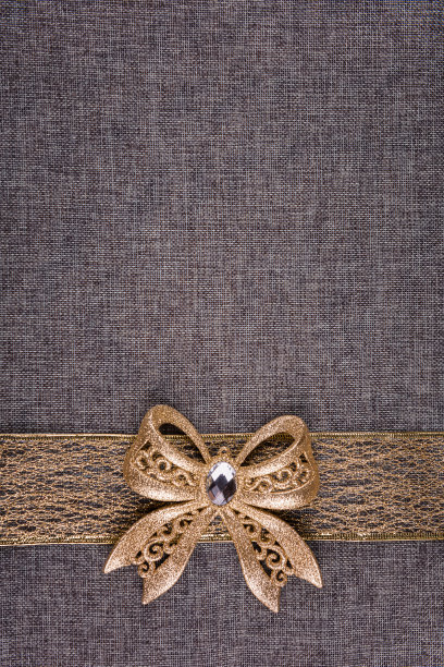 垂直图像与金色的蝴蝶结和丝带在灰色粗麻布上图片下载