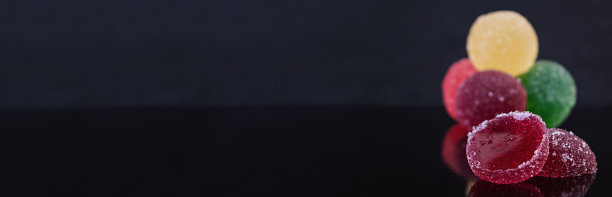 彩色的橘子酱孤立在黑暗的背景。美味的枣球。图片下载