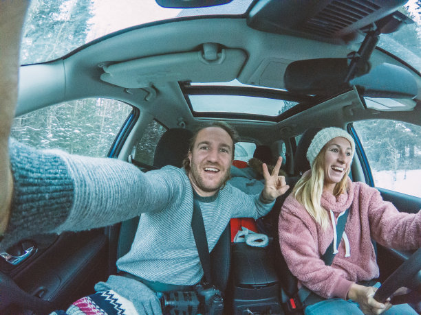 一对情侣在冬季公路旅行中自拍图片下载