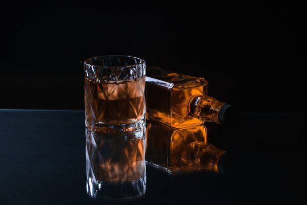 玻璃杯中的威士忌以冰橙为背景图片下载