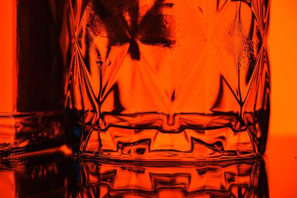 美丽的面玻璃威士忌上的红色背景特写。图片下载