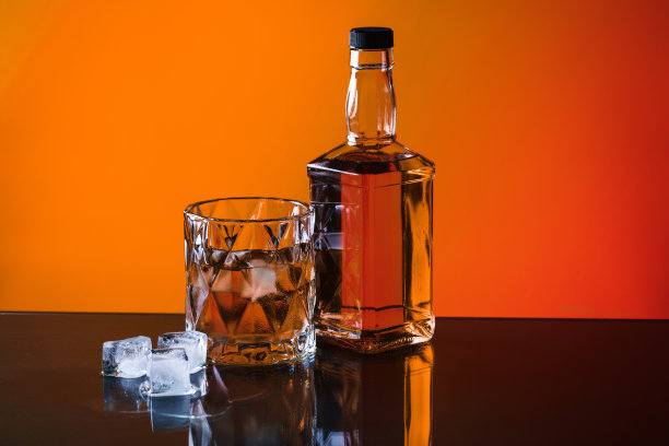 玻璃杯中的威士忌以冰橙为背景图片下载