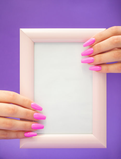 漂亮的手与粉红色指甲油拿着一个小的空白照片与框架图片下载