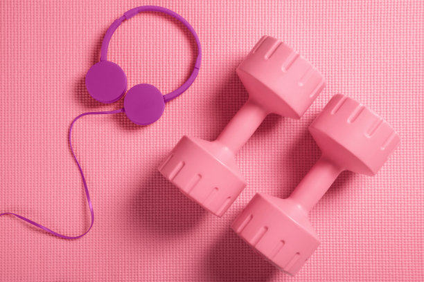 健身垫上放着哑铃和耳机图片下载