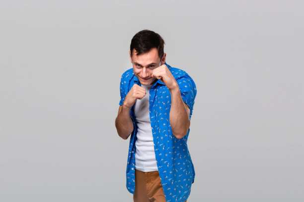 准备战斗的人站在一个拳击姿势孤立在灰色的背景。图片下载