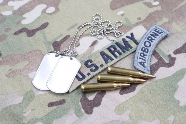 美国陆军空降兵臂章、旗帜布贴及军人身份牌，搭配5.56毫米子弹和迷彩服图片下载