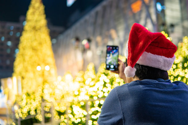 戴着圣诞帽的男人在圣诞活动中拍照图片下载