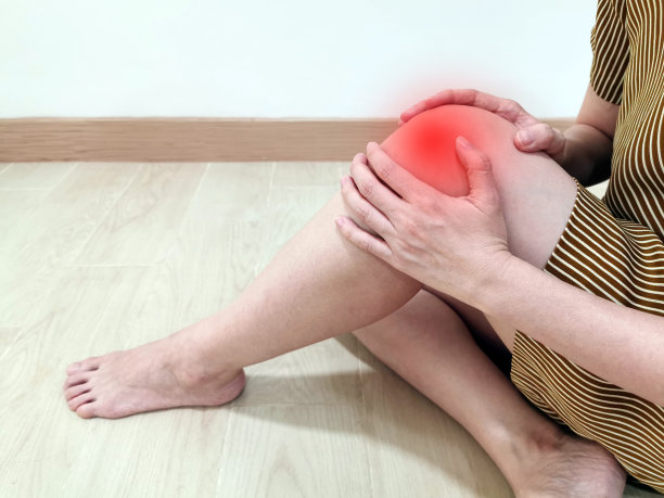 一位膝盖疼痛的年轻女性。膝关节疼痛可能由肌肉拉伤、肌腱炎、韧带扭伤、骨折或关节炎(OA)疾病引起。突出疼痛部位。医疗症状的概念图片下载