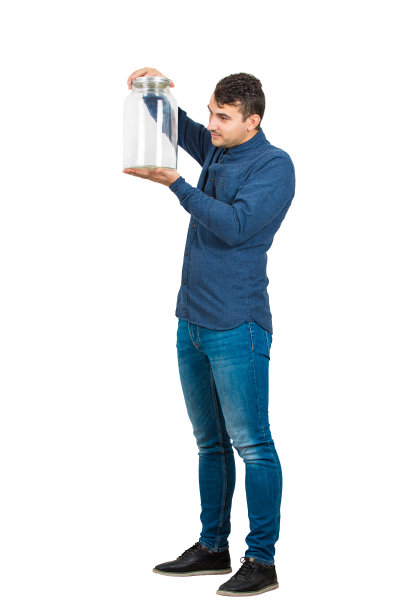 一个好奇的商人拿着一个空玻璃罐在他的手在白色的背景孤立的全长肖像。图片下载