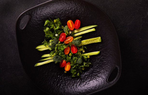 黄瓜、圣女果、西兰花和欧芹沙拉（黑色盘子，深色背景）图片下载