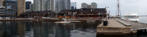 全景的城市天际线与多个摩天大楼和码头与汽车和船在湖边，海洋或水体图片下载