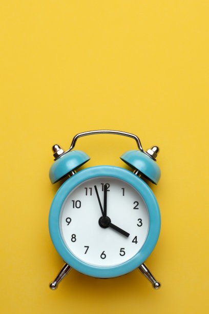 青色背景上的蓝色圆形闹钟。图片下载