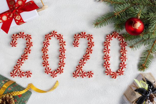 圣诞框架由冷杉树枝，糖果，礼物，红球与新年的象征和装饰。圣诞壁纸。图片下载