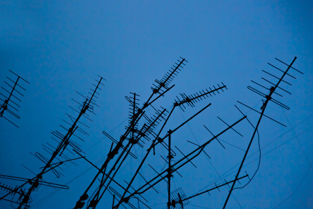 许多电视信号天线蓝色夜空中的剪影图片下载