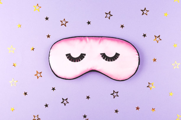 可爱的粉色睡眠面膜在紫色的背景。图片下载