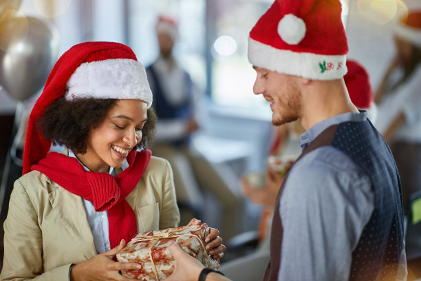 商人们庆祝圣诞节。同事在办公室庆祝圣诞节。图片下载