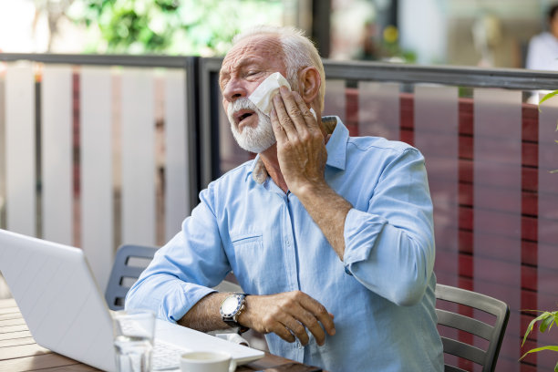 一个穿着西装的男人正坐在咖啡馆里，热得不行图片下载