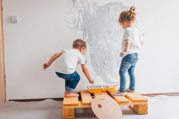 双胞胎兄弟在他们的房间里刷墙图片下载