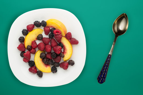 饮食,健康食品。黑莓、覆盆子、油桃放在盘子里的白色盘子里。素食食物的背景俯视图。图片下载