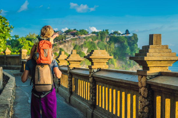 一对父子在印尼巴厘岛的Pura Luhur Uluwatu寺庙旅行。令人惊叹的景观-悬崖与蓝天和大海。和孩子一起旅行的概念图片下载