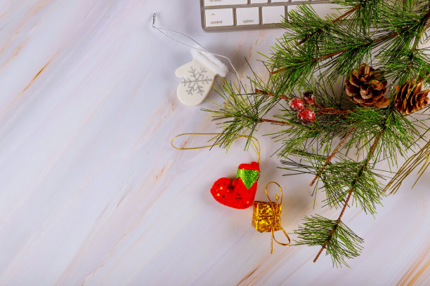 平铺家庭办公书桌与空间文本电脑键盘工作空间与精致的圣诞树树枝装饰品图片下载