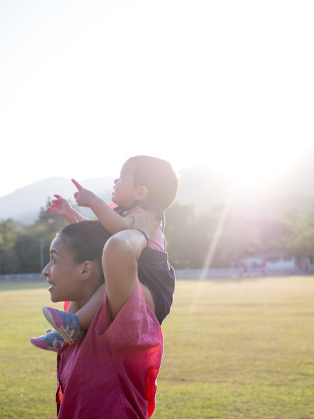 母亲的剪影紧紧抱着她的孩子，而她坐在母亲的头上。图片下载