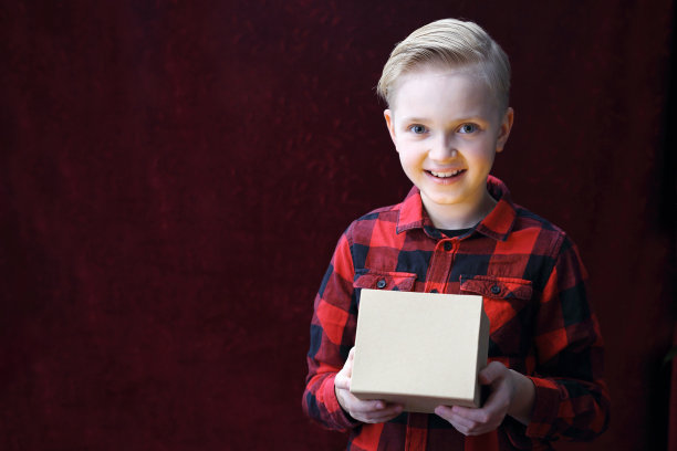 礼物，微笑的男孩带着圣诞礼物。图片下载