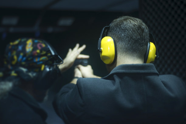 一个面目全非的教练在教如何射击，在射击场给年轻人做简报图片下载