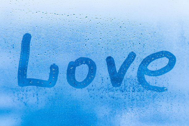 浪漫的爱情铭文在晚上或早晨的蓝色玻璃上与水滴图片下载