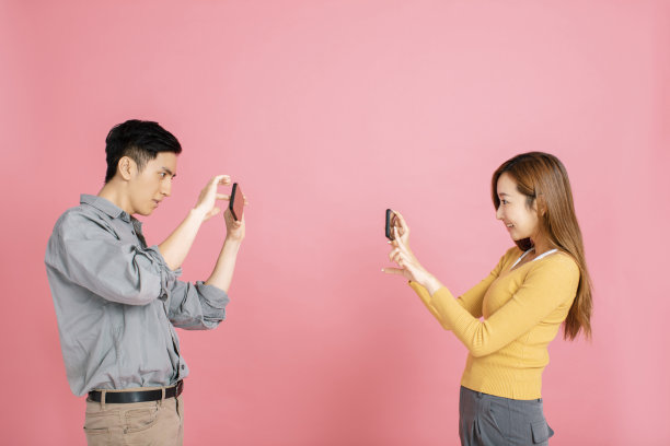 欢快的年轻夫妇用智能手机拍照图片下载