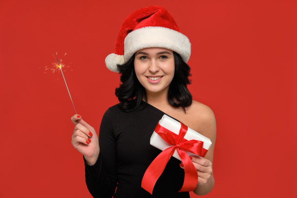 兴奋的女孩拿着孟加拉灯和gif盒子庆祝圣诞和新年图片下载