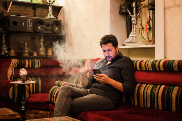 中东男子在传统沙发上抽水烟图片下载