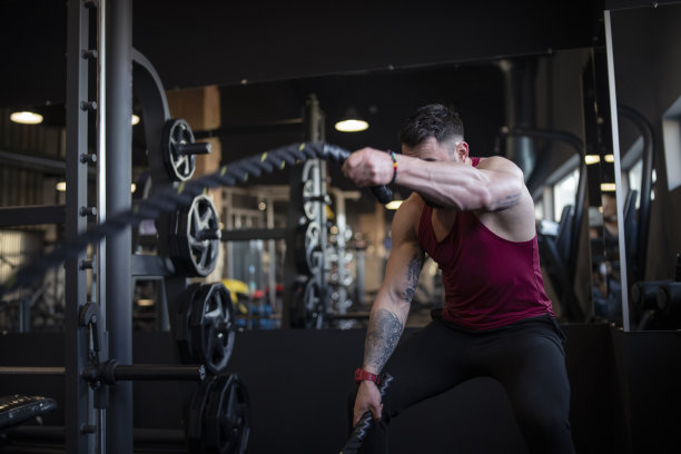 英俊的肌肉男正在做格斗绳练习，同时在健身房锻炼图片下载