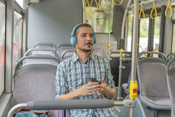 公共汽车上戴耳机的年轻人图片下载